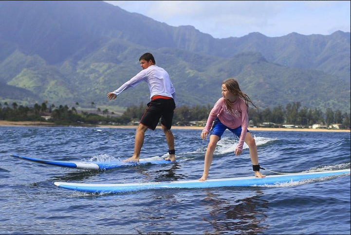 Children surfing during a kids lesson on Oahu's North Shore with North Shore Surf Girls