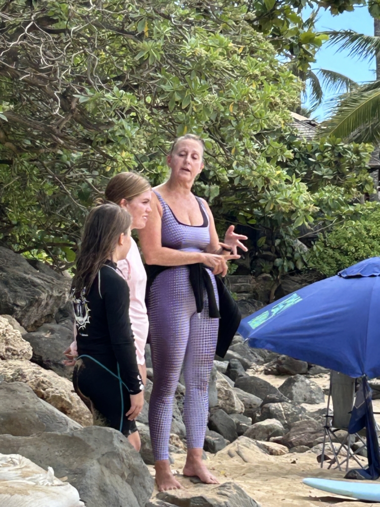 Surf instructor teaching safety rules to beginner surfers on the beach