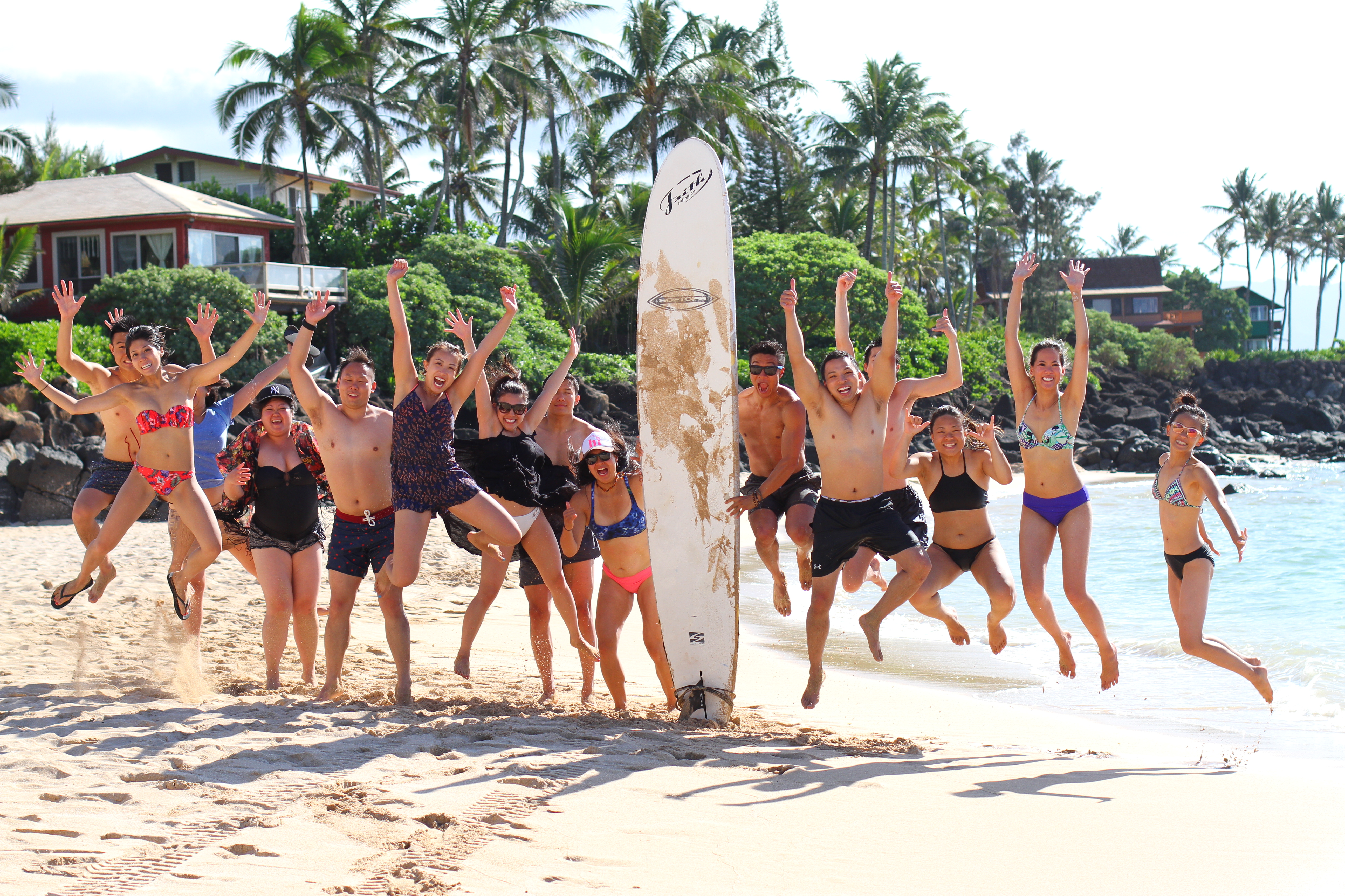 Group of beginner surfers celebrating after riding their first waves.